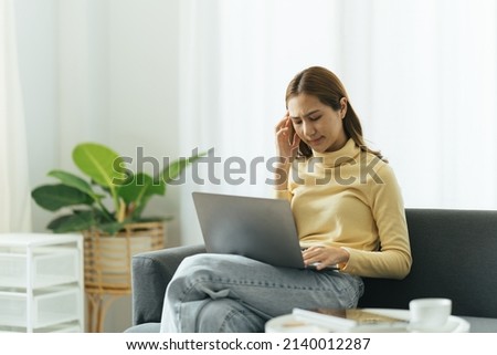 Freelance stress. Concerned asian girl freelancer tired after work on laptop at home, having problems with project, sitting on couch, free space Foto d'archivio © 