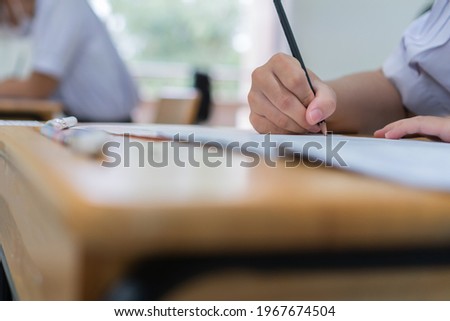 Hand female Asian students taking exam test and concentration reading document exercise at classroom in high school. Teenager notes for SAT PISA measurement educational, back to school for evaluation Stok fotoğraf © 