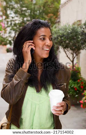 woman with coffee talking on the phone.