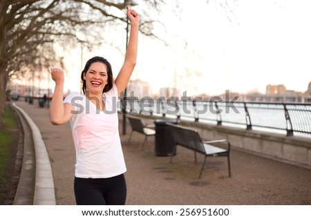 young woman outdoors celebrating a fitness goal