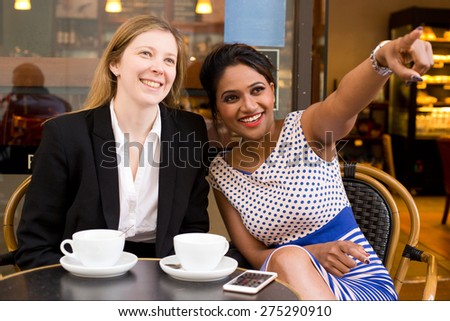 two ladies sitting at a coffee shop enjoying the day
