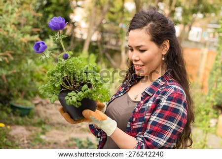 young woman reading a plant label.