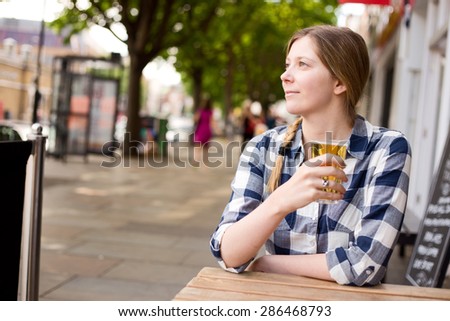 young woman enjoying a beer outside a bar