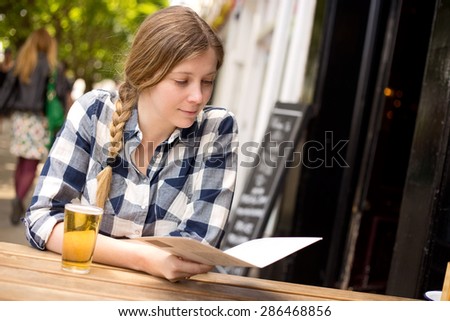 young woman looking at the menu at a bar