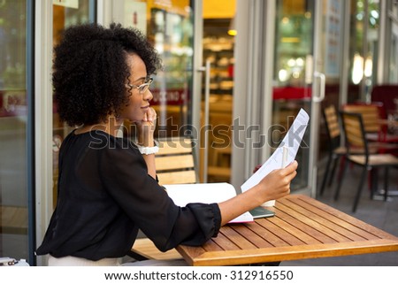 young woman at the coffee shop reading a document