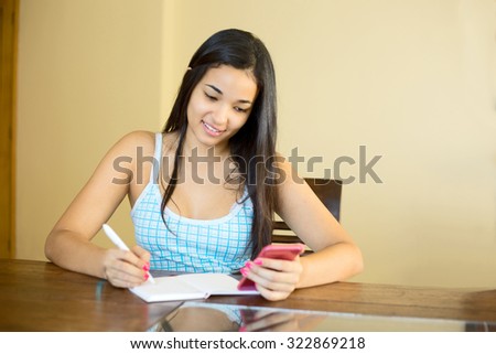 young woman copying her contact list into a notebook