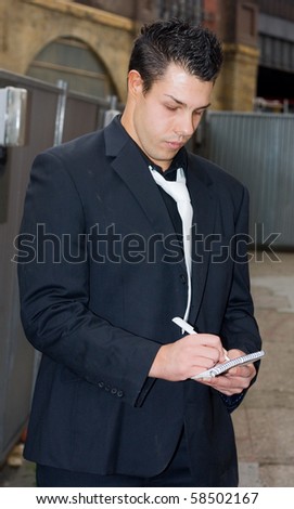 a business man writing on a pad of paper.