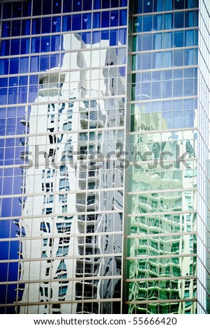 buildings reflected in the mirrored windows of a modern office building