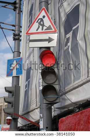 Red traffic light and different road signs
