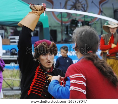 RUSSIA, MOLODI VILLAGE - JULY 27: Unidentified people in retro costume fight by the swords on event dedicated to Victory in battle near the Molodi village 1572, on July 27, 2013, Moscow region, Russia