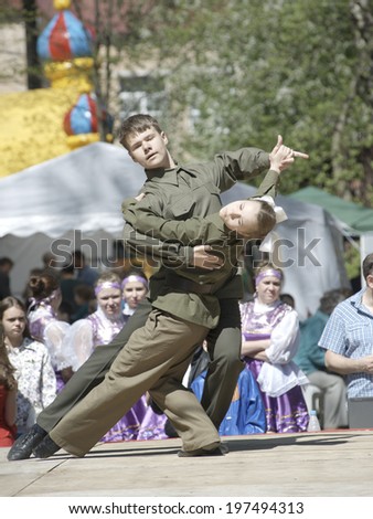 ELECTROUGLI, RUSSIA - MAY 9: Teen artists in military uniform dance tango on a concert dedicated The Victory day in World War II on May 9, 2014, in Electrougli city, Ivanovskoe village, Russia