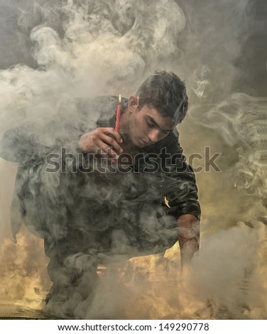 The guy with a candle searches in a smoke
