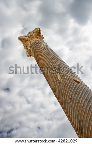 Top of pillar against sky and clouds