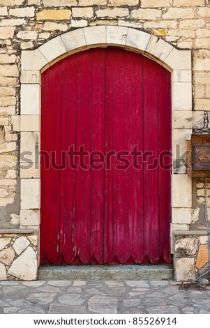 Old red door against an old stone wall