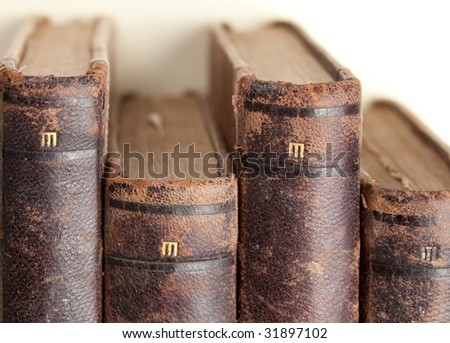 stack of old vintage books with brown leather backs