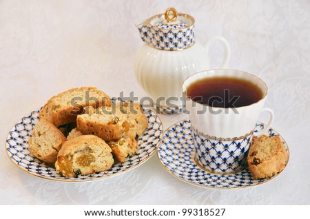 tea party with cup of tea, plate with cakes and milk jug on white background