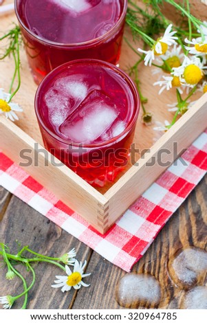 Fruit drink with ice glass jars on a wooden tray