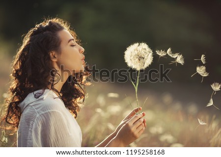 Similar – Image, Stock Photo Woman blowing dandelion in forest during picnic