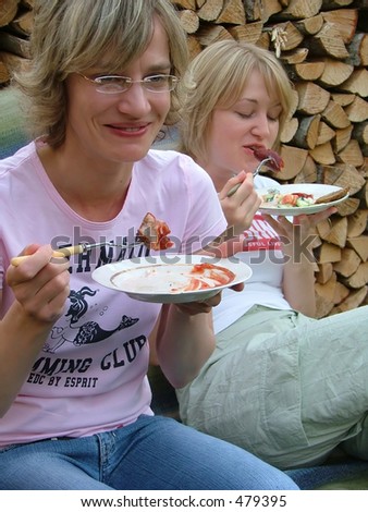 two women eating barbequed meat