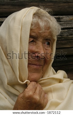 old woman wrapped in a beige scarf