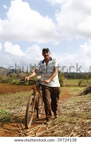 VINALES, CUBA - MARCH 20: Man walks with old rusty bike in Cuban countryside in Vinales on March 20, 2009. Most Cubans live way below established poverty lines, the issue is biggest in rural areas.