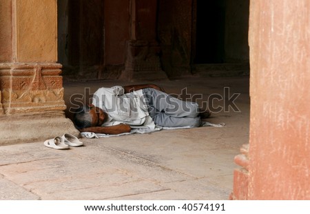 DELHI, INDIA - JUNE 18: An Indian man sleeping on the street in Delhi, India on 18th June 2007. Poverty is a huge issue in India, there are specially many homeless and poor people in the Indian cities
