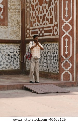 SIKANDRA, INDIA - JULY 3rd: Hindu man praying by the Akbar\'s Tomb temple. More than 80% of Indian population follow Hinduism, as does the man on the picture on July 3rd, 2007 in Sikandra, India.