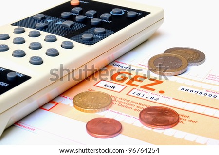 TV remote control and money coins on top of a invoice for radio and television license fees