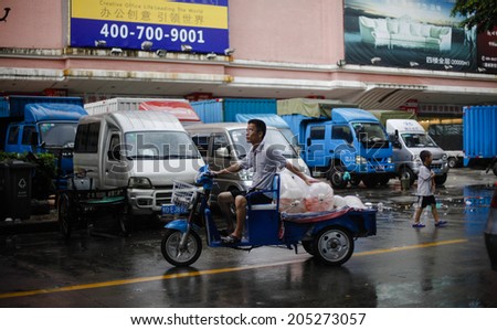 GUANGZHOU, CHINA - JUNE 24.:Man driving on his motorcycle bags with live fishes for aquariums on Yihe Market. Yihe Market is one of the biggest wholesale markets for fish products in China.