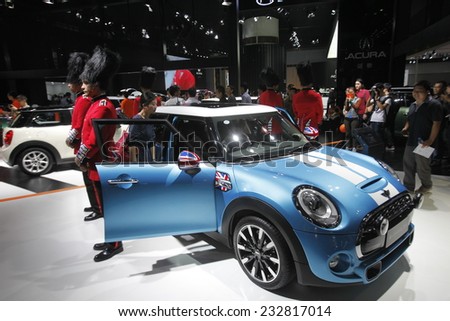 GUANGZHOU, CHINA - NOV. 22. 2014: Models wear costumes resembling Buckingham Palace guards stand around a Mini Cooper during the 12th China International Automobile Exhibition.