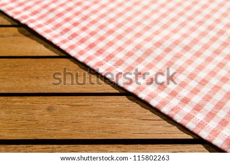 Red white checkered table cloth on a wooden table