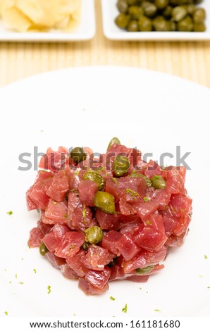 Tatar of raw tuna fish with green capers in vertical format