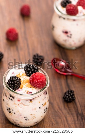 Raspberries and blackberries with yoghurt in vertical format