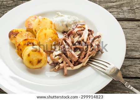 Salad with sausages and cheese and chips and curd on a plate