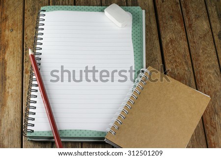 notepad and pencil on a wood desk, add your text here.