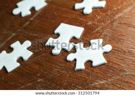 white jigsaw puzzle in wood background.