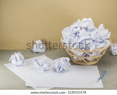 waste paper document in bin is overflow on work table.