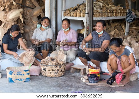 UBUD, BALI, INDONESIA - MARCH 23, 2015 : Unidentified women are making wooden souvenirs for tourists. Woodcarving is a traditional handicraft in Bali