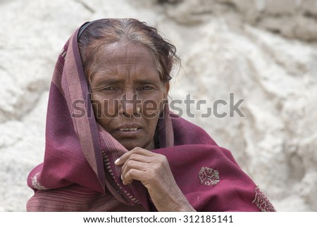 LEH, INDIA - JUNE 24, 2015: Unknown beggar woman begging on the street in Leh, Ladakh. Poverty is a major issue in India