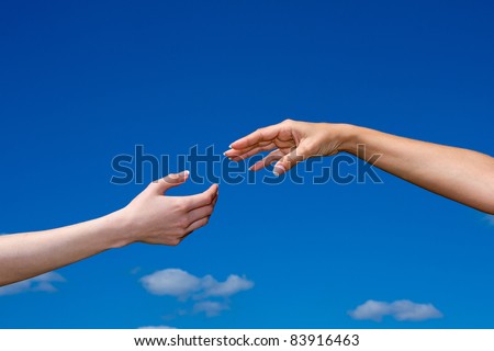 Hand reaching out from the blue sky