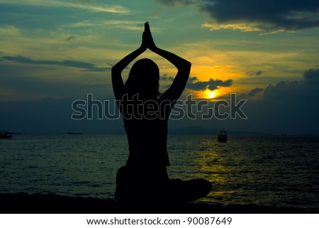 Healthy woman doing yoga outdoor, sunset over sea