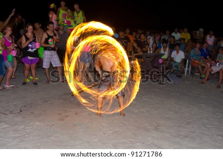 PHANGAN - DECEMBER 10 : There are about 10,000 people every month at this Phangan beach Full moon party, on December 10, 2011 in Koh Phangan , Thailand . Fire dancer on a beach  - blur