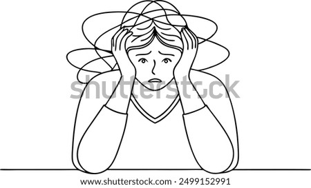 A woman is sitting at a table with her head in her hands. She looks very sad and worried