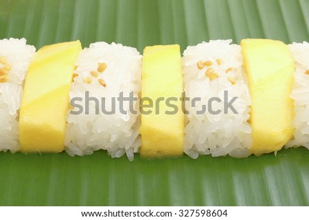 Mango sticky rice on banana leaf and wooden plate