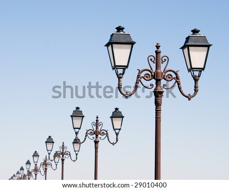 A row of lanterns runs along a beach-side promenade in southern France.