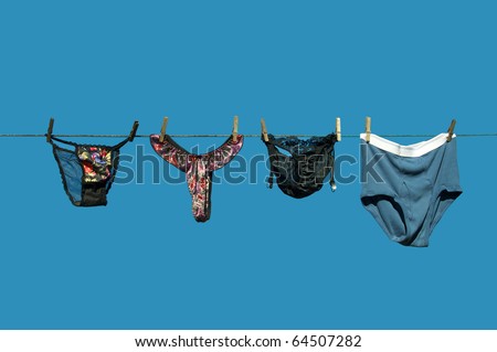 Lingerie  beside men\'s briefs hanging on a clothesline against a brilliant blue sky with copy space.