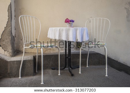 table with two chairs on stone stairs