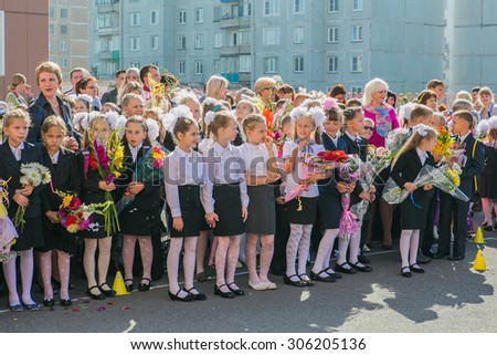 NOVOKUZNETSK, KEMEROVO REGION, RUSSIA - SEPTEMBER, 1, 2014: Meeting with the first-grade pupils and teacher at schoolyard. The day of knowledge in Russia.