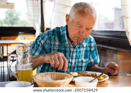 gray haired señor dines on the terrace restaurant in the afternoon Foto stock © 