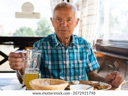 gray haired señor dines on the terrace restaurant in the afternoon Foto stock © 